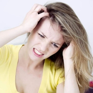 Frau kratzt sich am Kopf